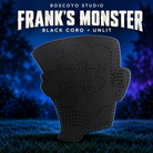 Boscoyo Frank's Monster black coro option, original flat unlit head silhouette with empty pixel holes, on a dark blue evening yard.